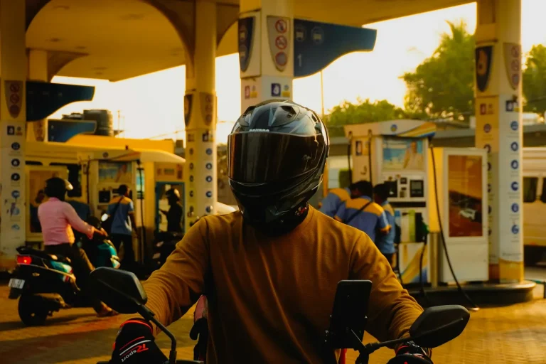 Motard casqué dans une station-service au crépuscule