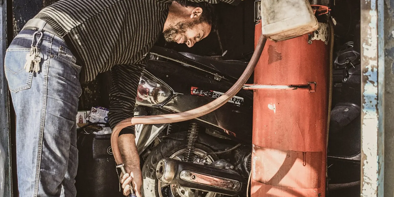 Plein de carburant à une pompe à essence, une moto en arrière-plan