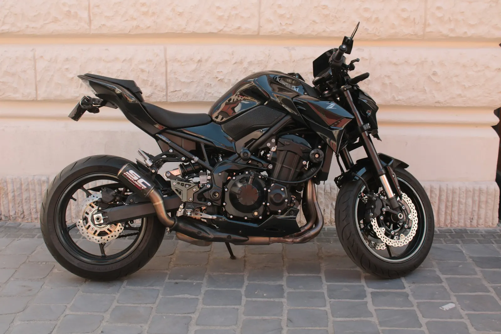 Roadster noir stationné dans une rue pavée